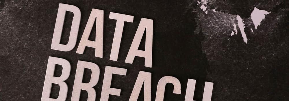 The words data breach set in stencil type on a worn surface
